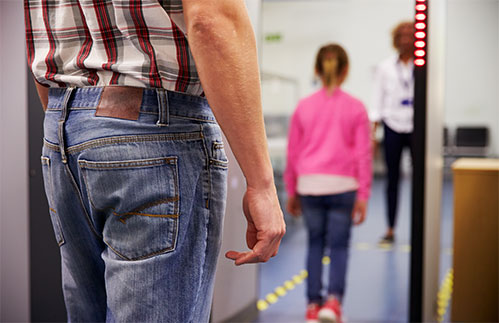 student walking through a metal detector at school